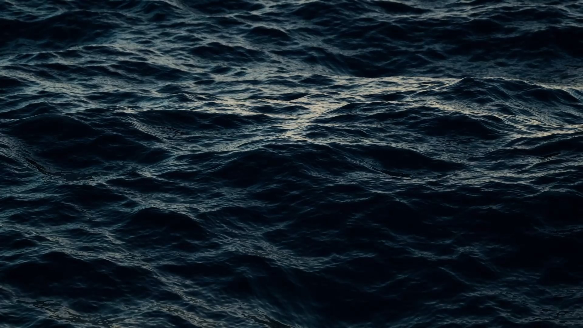 Dark, choppy ocean waves with subtle reflections of light.